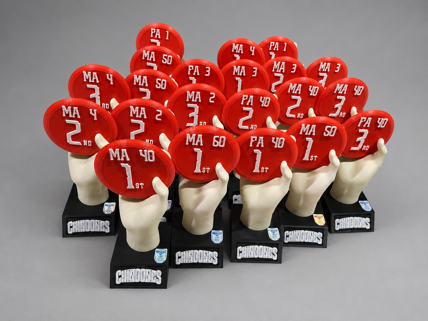 Trofeos personalizados impresos en 3D multicolor con forma de manos sosteniendo discos, fabricados por ICONO3D para torneo de disc golf